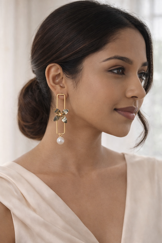Woman wearing elegant earrings with a neutral background